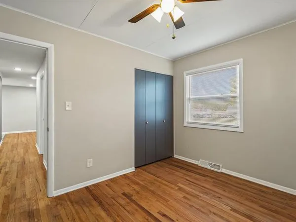 an empty room with a window and ceiling fan