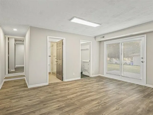 a view of an empty room with wooden floor and cabinet