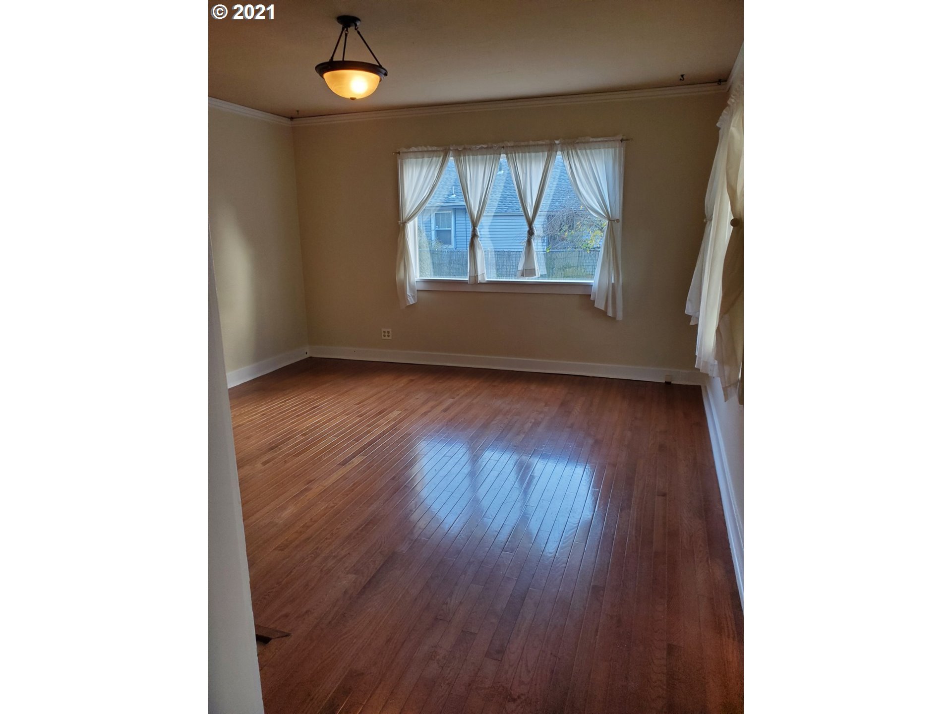 767 Madison Street Eugene, OR 97402 - Photo 2 of 20 a view of an empty room with wooden floor and a window