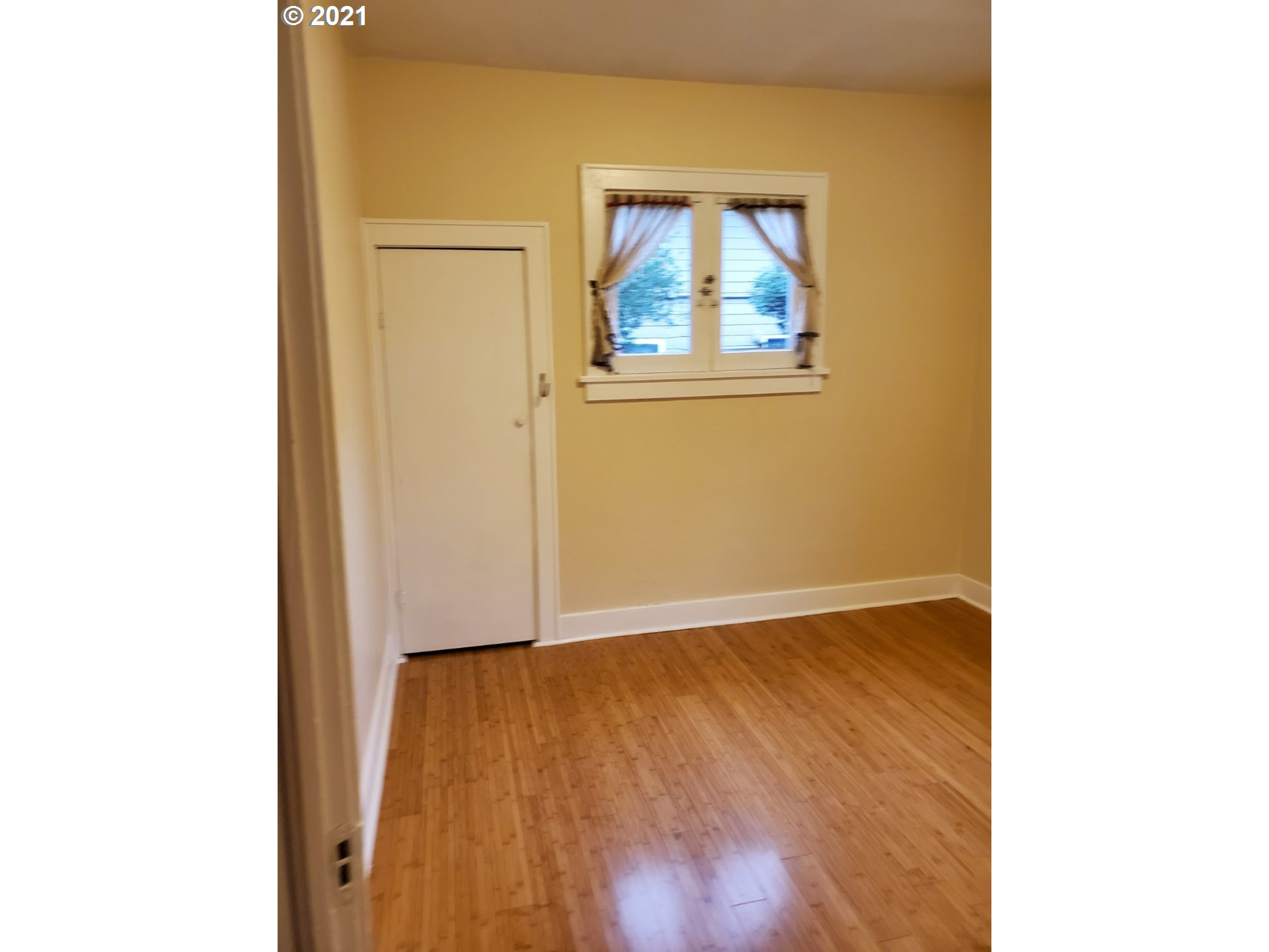 767 Madison Street Eugene, OR 97402 - Photo 9 of 20 a view of an empty room with wooden floor and a window