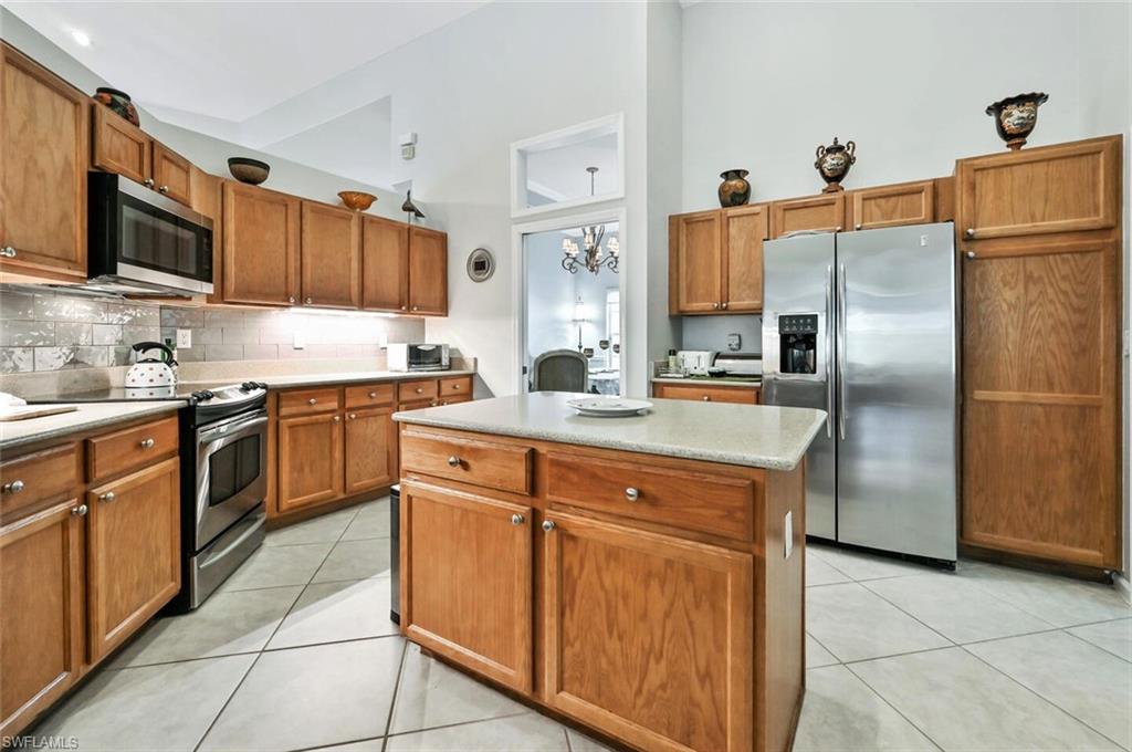 6545 Chestnut Circle Naples, FL 34109 - Photo 13 of 43 a kitchen with stainless steel appliances granite countertop a refrigerator a sink a stove top oven and cabinets
