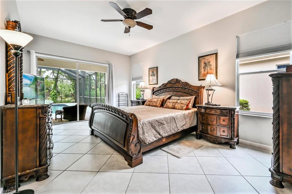 6545 Chestnut Circle Naples, FL 34109 - Photo 17 of 43 a bedroom with a bed and a chandelier