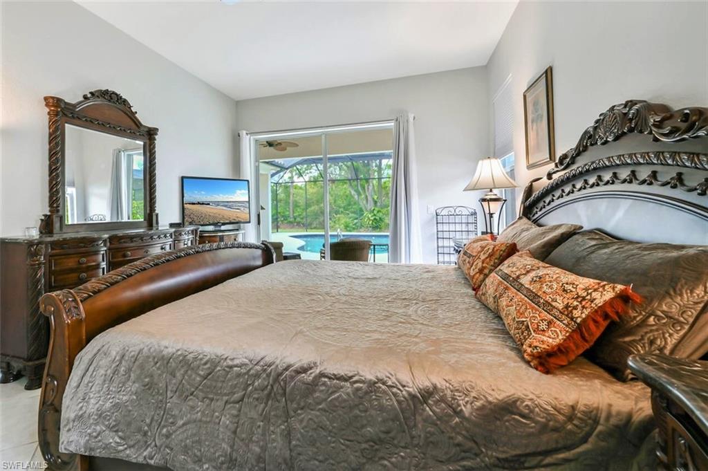 6545 Chestnut Circle Naples, FL 34109 - Photo 18 of 43 a bedroom with a bed and a chair