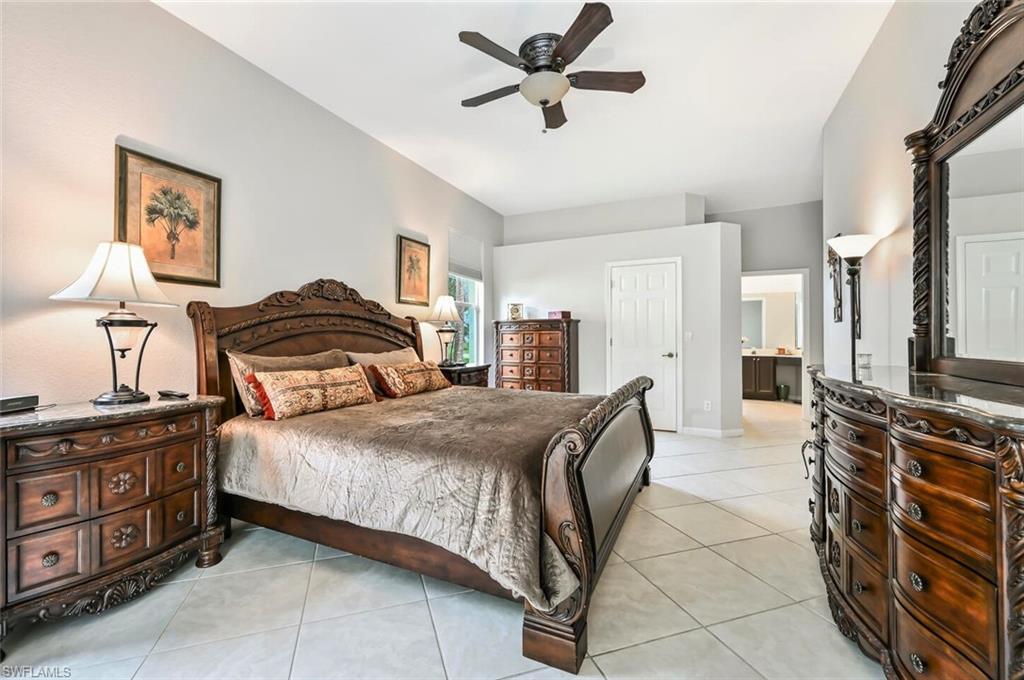 6545 Chestnut Circle Naples, FL 34109 - Photo 19 of 43 a bedroom with a bed and a chandelier