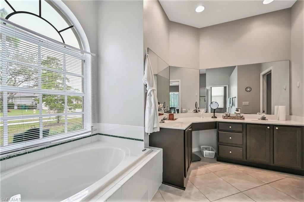 6545 Chestnut Circle Naples, FL 34109 - Photo 22 of 43 a spacious bathroom with a tub sink and mirror