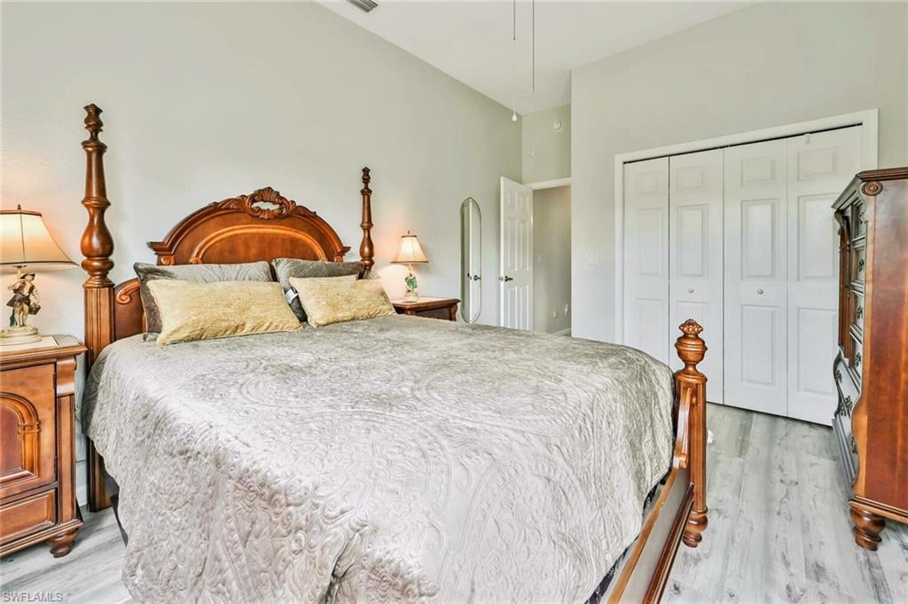 6545 Chestnut Circle Naples, FL 34109 - Photo 24 of 43 a bedroom with a bed and a dresser with wooden floor