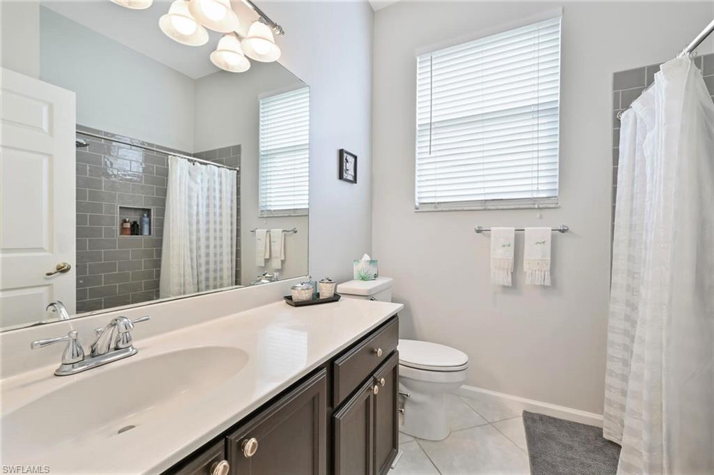 6545 Chestnut Circle Naples, FL 34109 - Photo 25 of 43 a bathroom with a granite countertop sink toilet and mirror