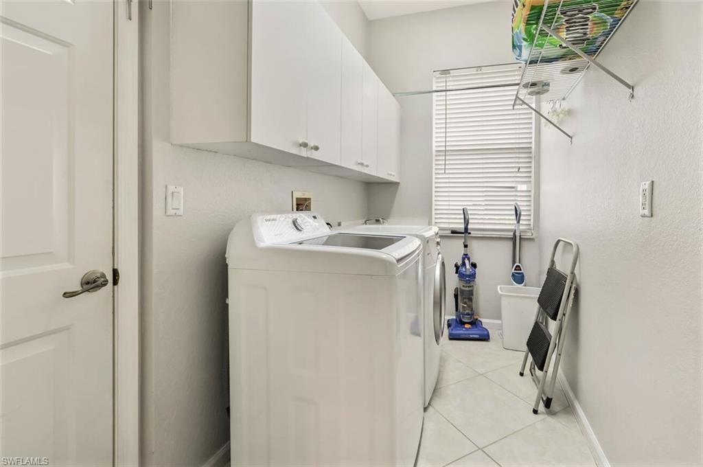 6545 Chestnut Circle Naples, FL 34109 - Photo 28 of 43 a utility room with cabinets washer and dryer