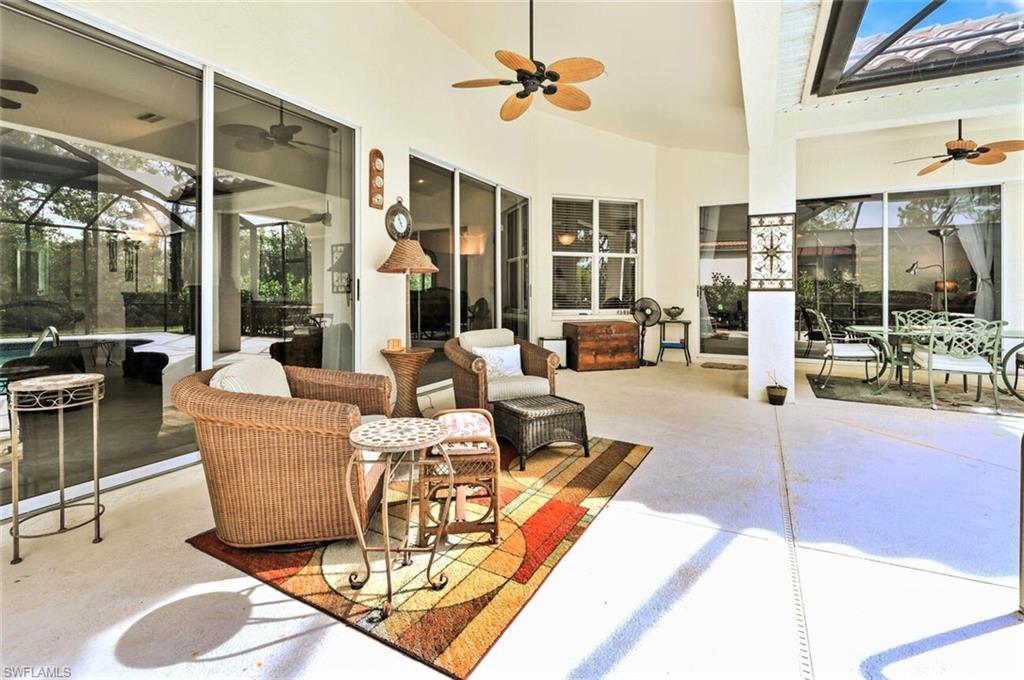 6545 Chestnut Circle Naples, FL 34109 - Photo 30 of 43 a living room with couch a dining table and a floor to ceiling window