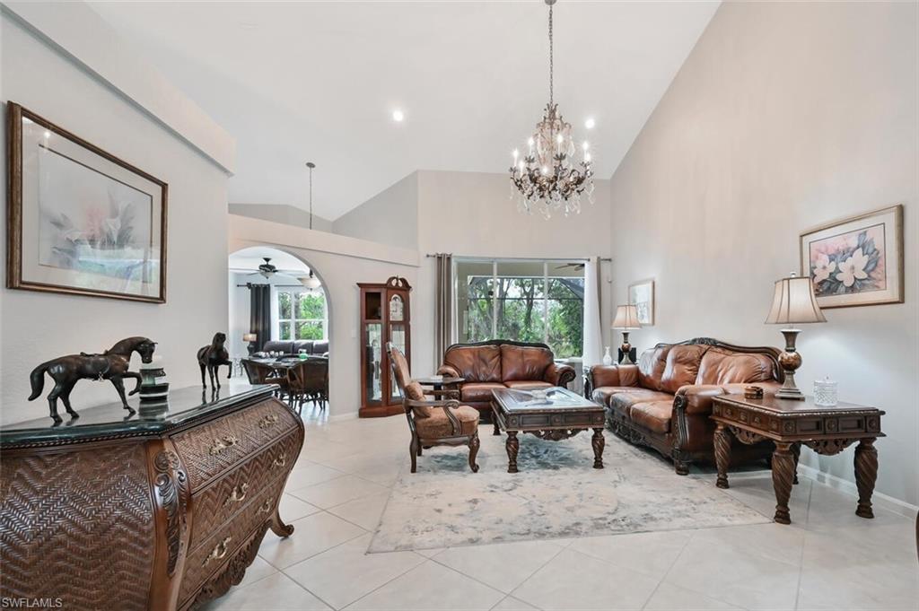 6545 Chestnut Circle Naples, FL 34109 - Photo 5 of 43 a living room with furniture two window and a chandelier