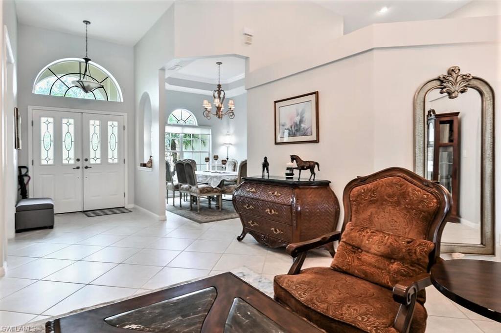 6545 Chestnut Circle Naples, FL 34109 - Photo 7 of 43 a living room with furniture a chandelier and a window