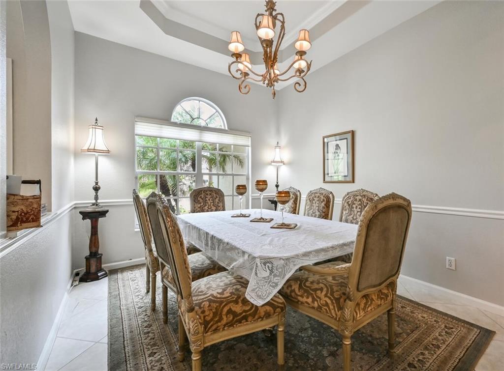 6545 Chestnut Circle Naples, FL 34109 - Photo 8 of 43 a view of a dining room with furniture a chandelier and wooden floor