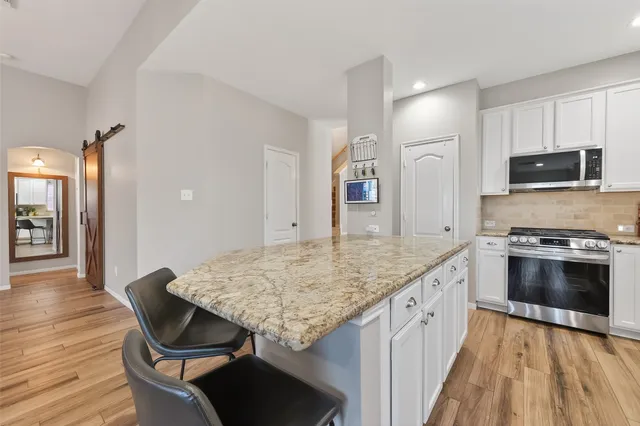 a kitchen with stainless steel appliances kitchen island granite countertop a stove top oven a sink and dishwasher