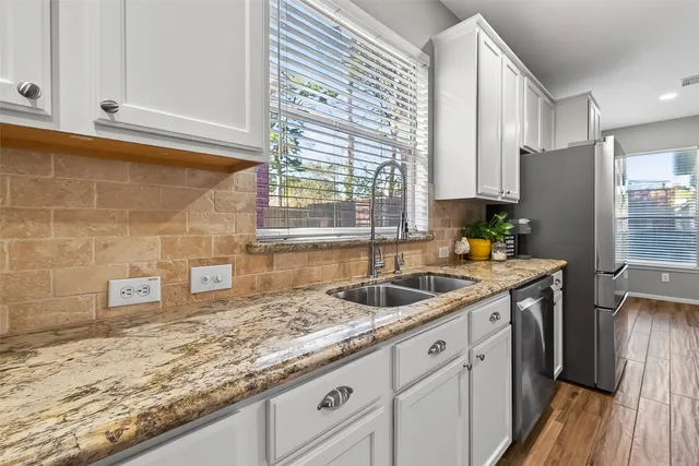 a kitchen with granite countertop a sink and a refrigerator