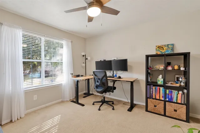 a view of a workspace with furniture and a window