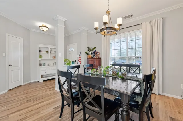 a dining room with furniture a chandelier and wooden floor