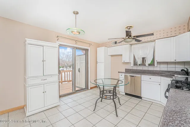 a kitchen with stainless steel appliances a stove a refrigerator and white cabinets with wooden floor