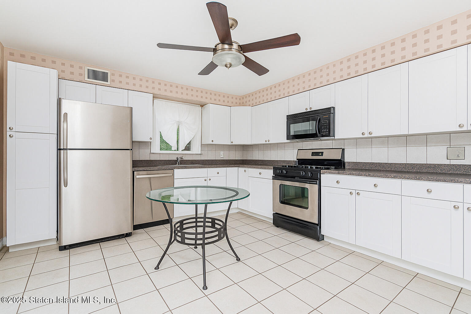 318 Travis Avenue Staten Island, NY 10314 - Photo 7 of 24 a kitchen with stainless steel appliances granite countertop a refrigerator a stove a sink dishwasher and a refrigerator