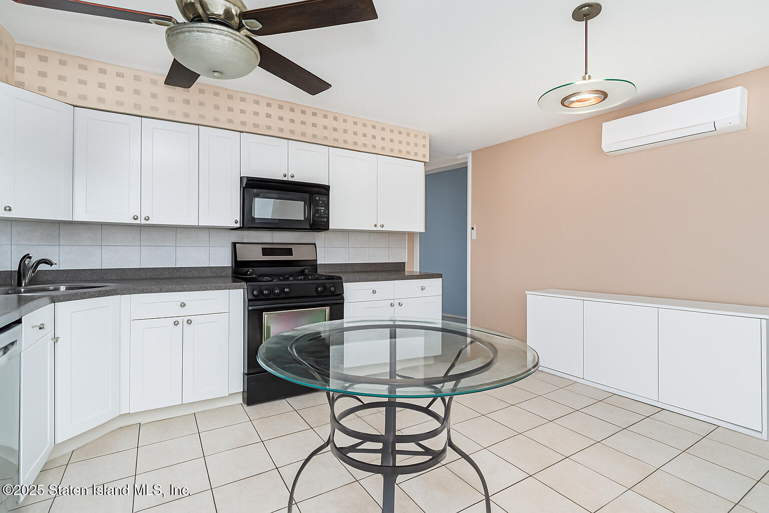 318 Travis Avenue Staten Island, NY 10314 - Photo 8 of 24 a kitchen with stainless steel appliances a stove a refrigerator and white cabinets with wooden floor