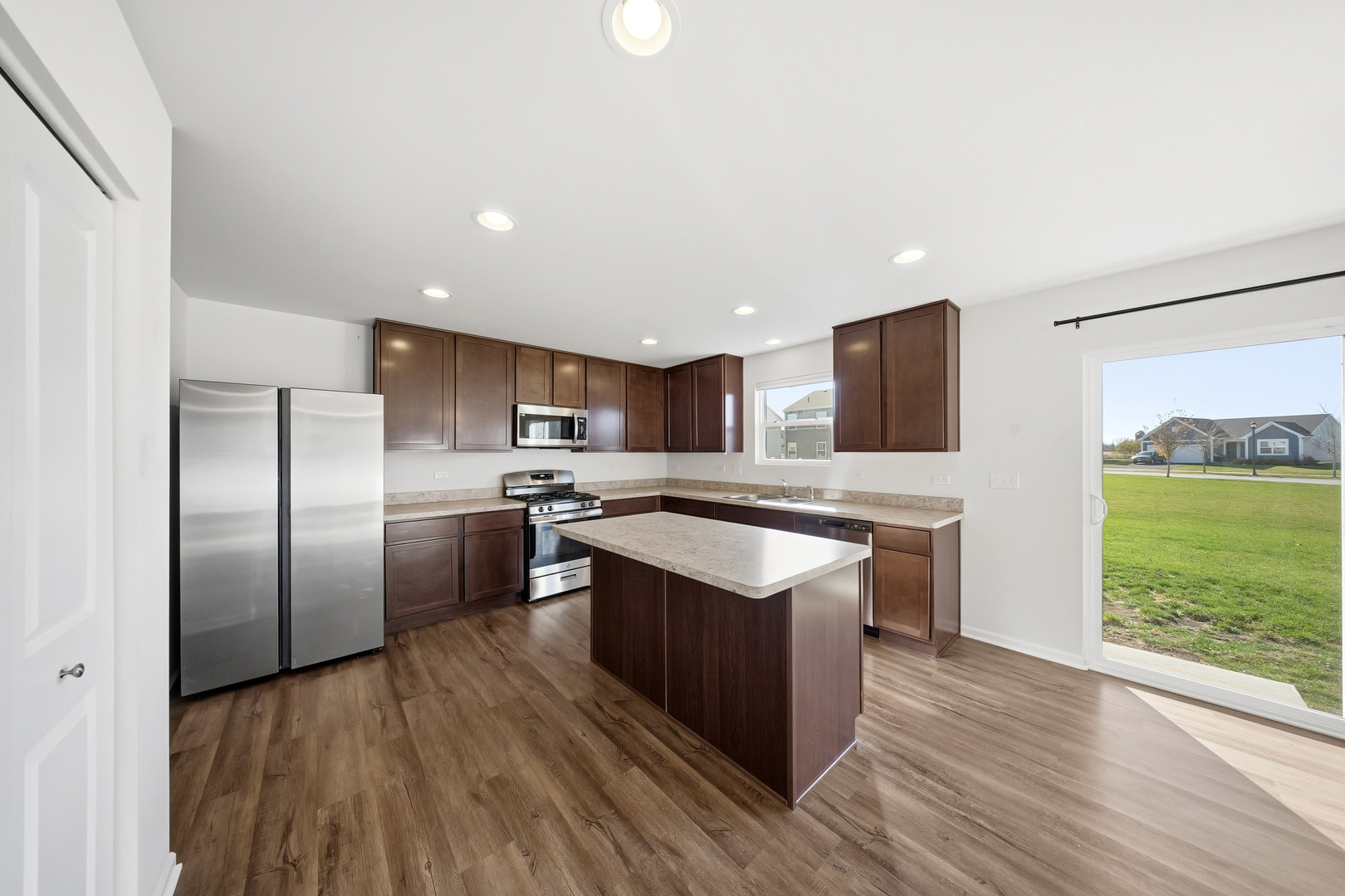 949 Hyte Street Plano, IL 60545 - Photo 12 of 51 a kitchen with stainless steel appliances granite countertop a stove a sink dishwasher a refrigerator and a oven with wooden floor