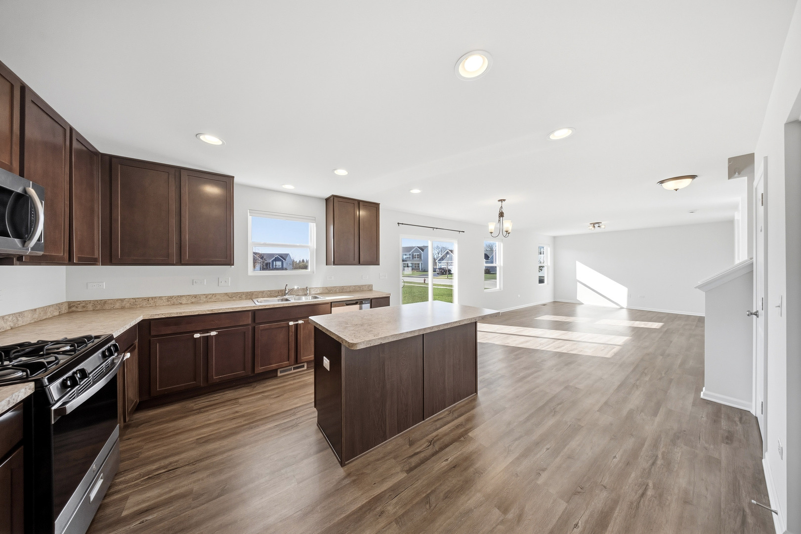 949 Hyte Street Plano, IL 60545 - Photo 14 of 51 a large kitchen with stainless steel appliances granite countertop a lot of counter space and wooden floor