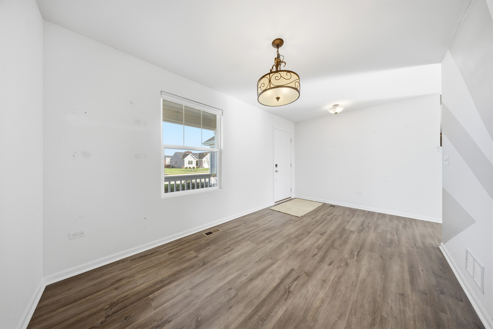949 Hyte Street Plano, IL 60545 - Photo 6 of 51 an empty room with wooden floor and windows