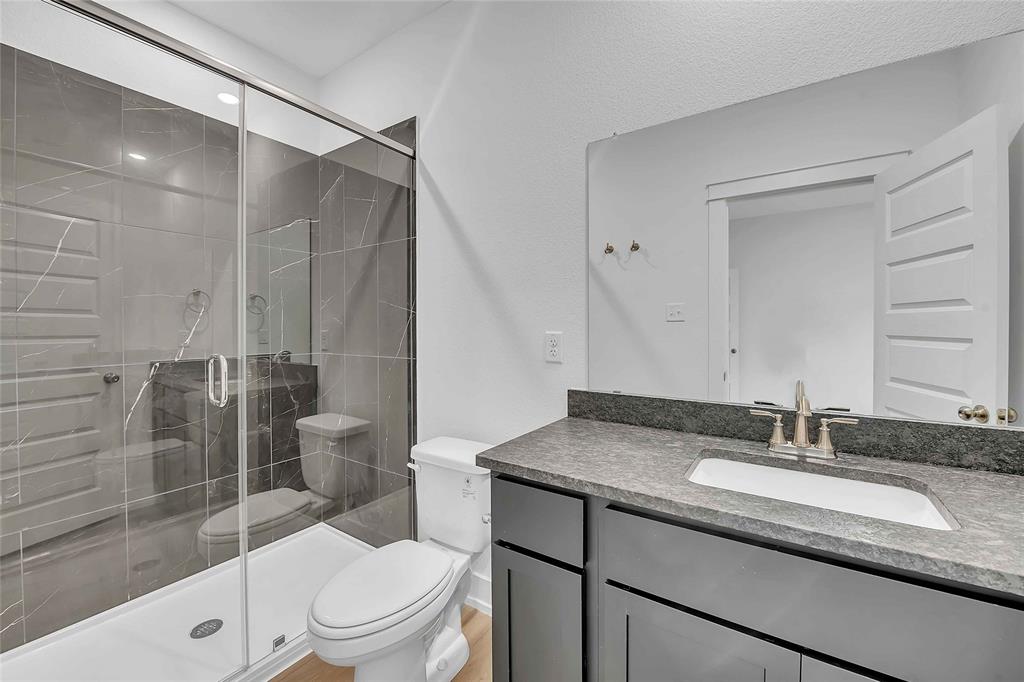 2812 Teasdale Road Lorena, TX 76655 - Photo 11 of 15 a bathroom with a granite countertop sink toilet a mirror and shower