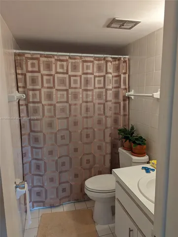 a bathroom with a sink a toilet and shower curtain