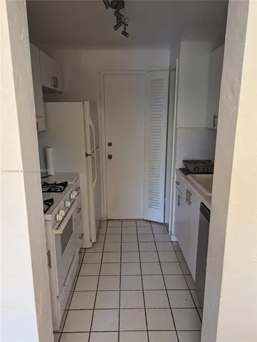 a kitchen with a sink a refrigerator and cabinets