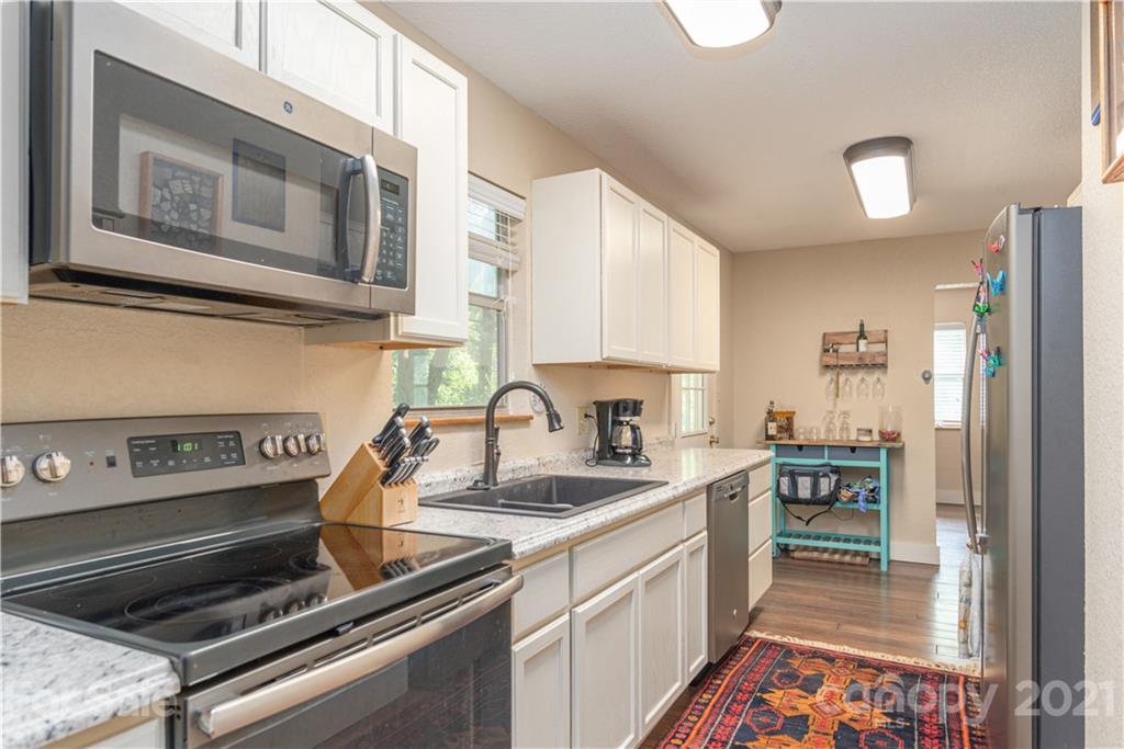 1035 County Road Waynesville, NC 28785 - Photo 6 of 15 a kitchen with a sink stove and refrigerator
