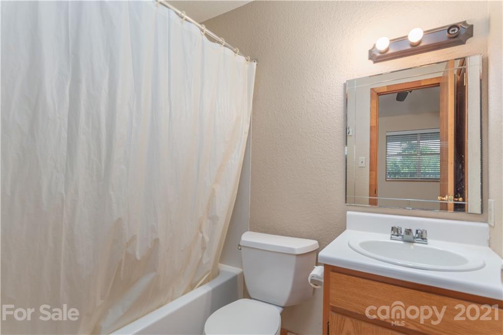 1035 County Road Waynesville, NC 28785 - Photo 8 of 15 a bathroom with a granite countertop sink toilet and mirror