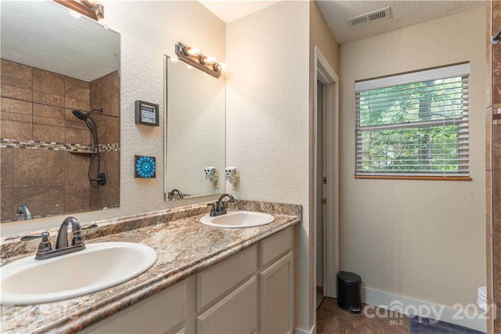 1035 County Road Waynesville, NC 28785 - Photo 10 of 15 a bathroom with a granite countertop sink and a mirror