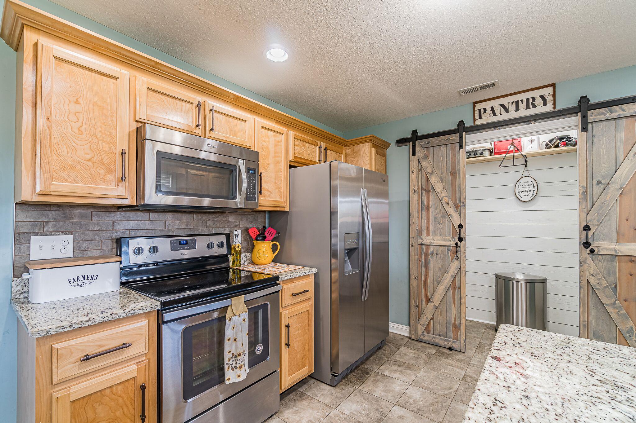 1753 Springhaven Drive Clarksville, TN 37042 - Photo 5 of 18 a kitchen with stainless steel appliances granite countertop a stove a refrigerator and a microwave