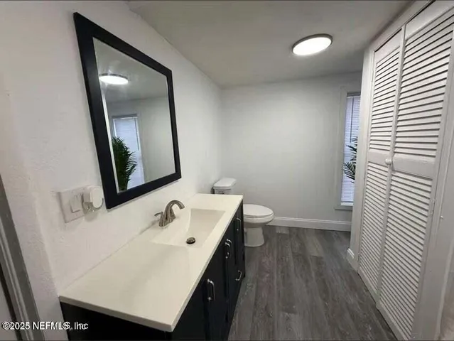 a bathroom with a sink a toilet and mirror