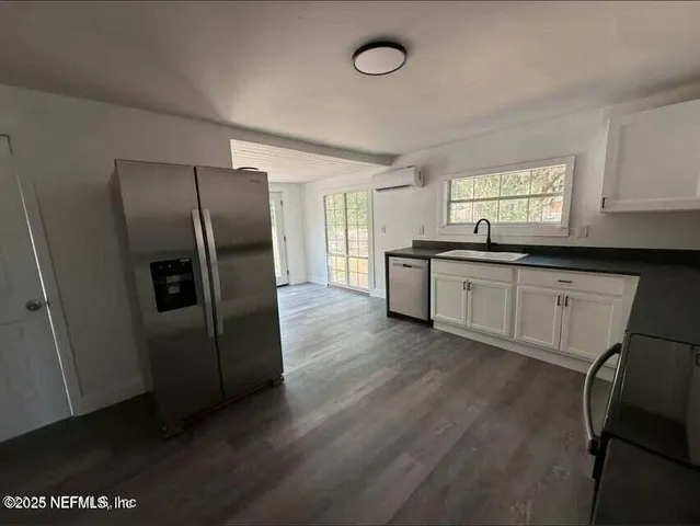 a kitchen with stainless steel appliances granite countertop a refrigerator a sink dishwasher a stove and a refrigerator