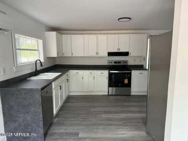 a kitchen with stainless steel appliances granite countertop a stove a sink and a granite counter tops