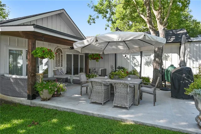 a view of a patio with table and chairs under an umbrella
