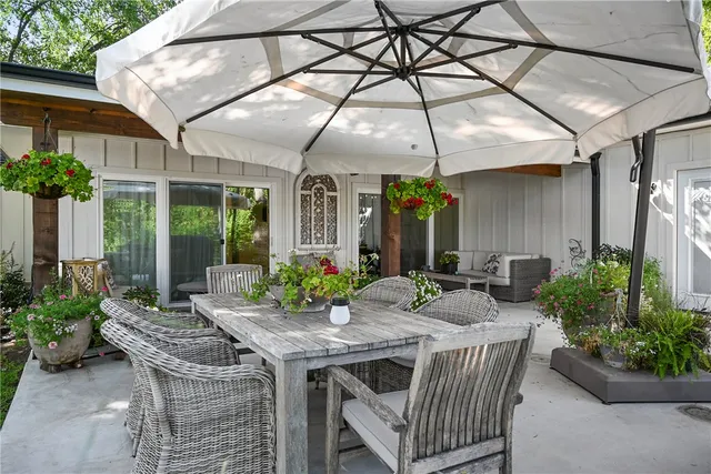 a patio with a table and chairs and potted plants