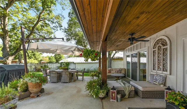 a view of a patio with table and chairs potted plants and large tree