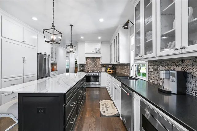a kitchen with stainless steel appliances granite countertop a sink stove and refrigerator