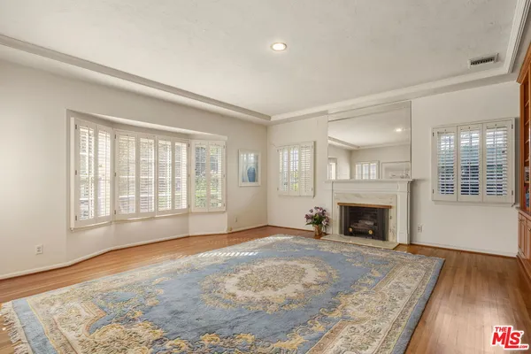 a view of empty room with wooden floor and fireplace