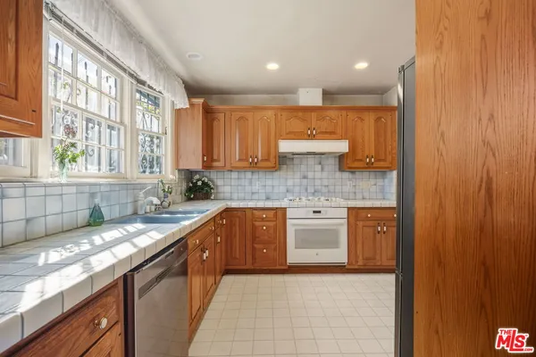 a kitchen with stainless steel appliances granite countertop a sink stove and cabinets