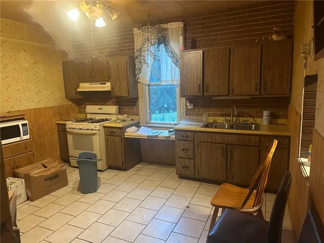 a kitchen with a sink a stove cabinets and utility room