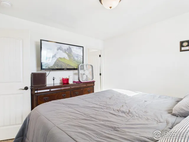 a bedroom with bed and a baby crib