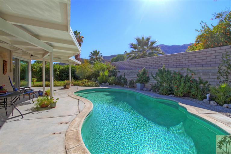 71705 Tunis Road Rancho Mirage, CA 92270 - Photo 29 of 29 a view of a patio with couches table and chairs under an umbrella next to a yard