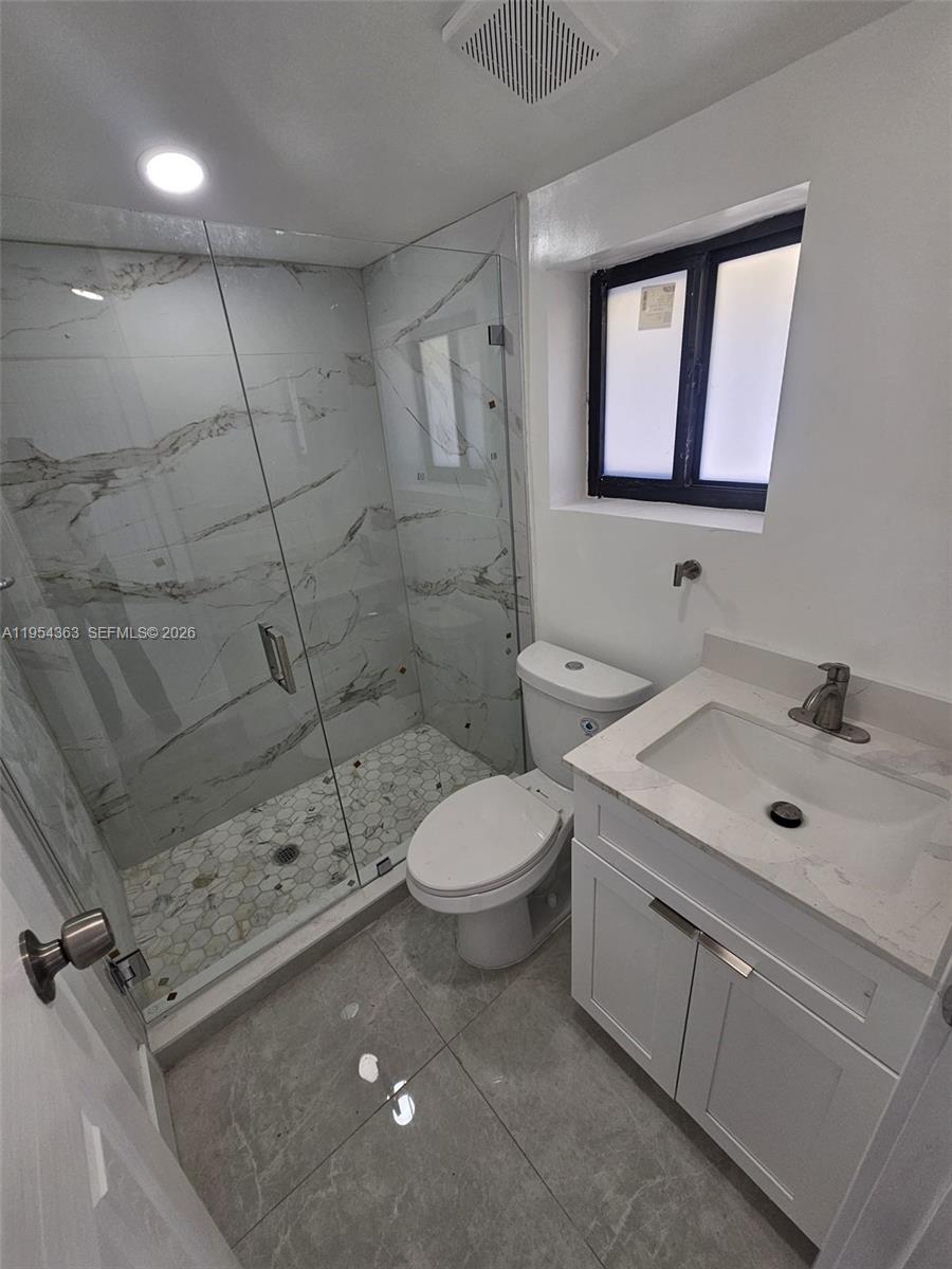 1148 Northwest 100th Street, Unit 1 Miami, FL 33150 - Photo 11 of 32 a bathroom with a sink a toilet and shower