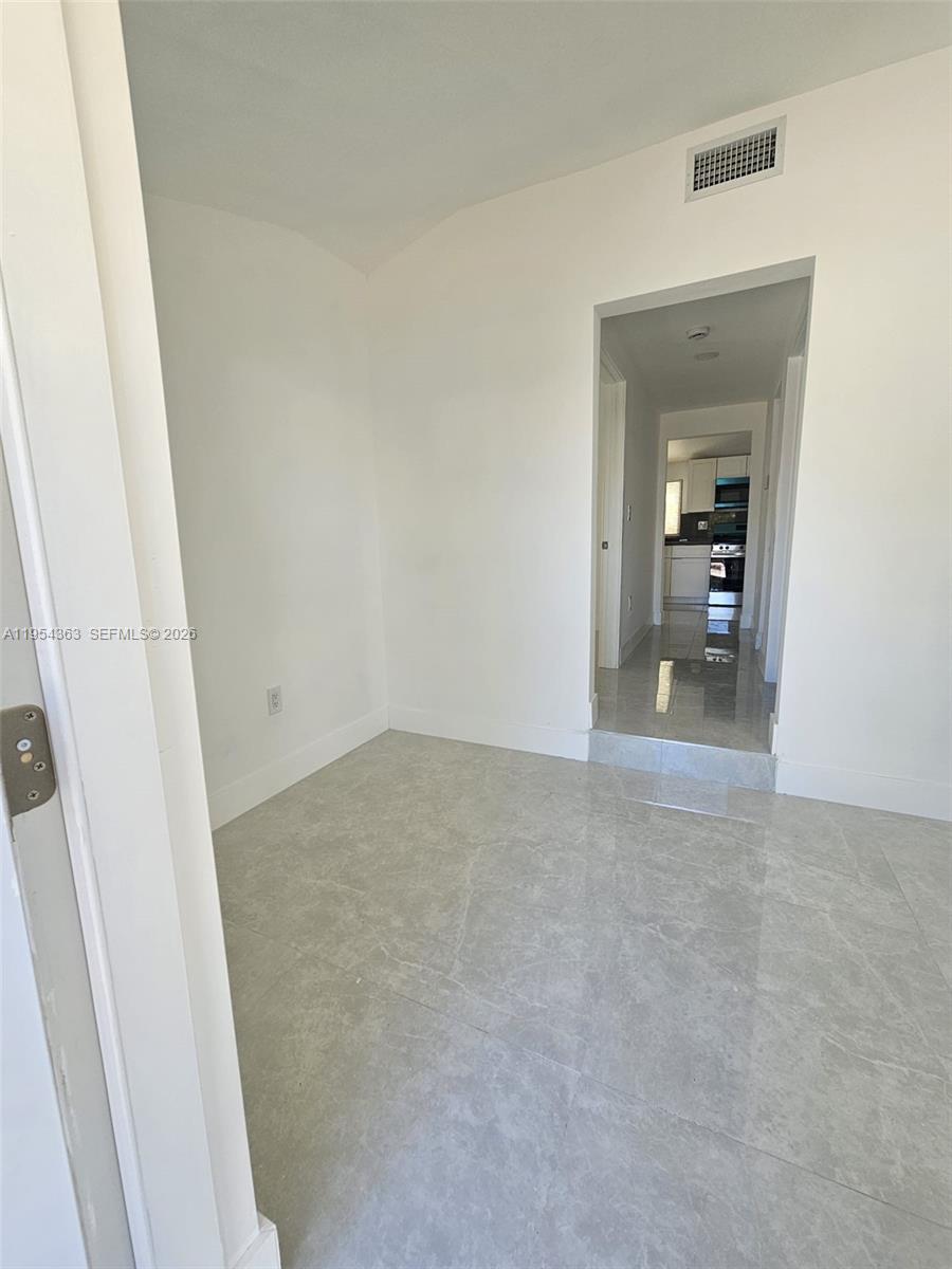 1148 Northwest 100th Street, Unit 1 Miami, FL 33150 - Photo 5 of 32 a view of a room with an empty space and wooden floor