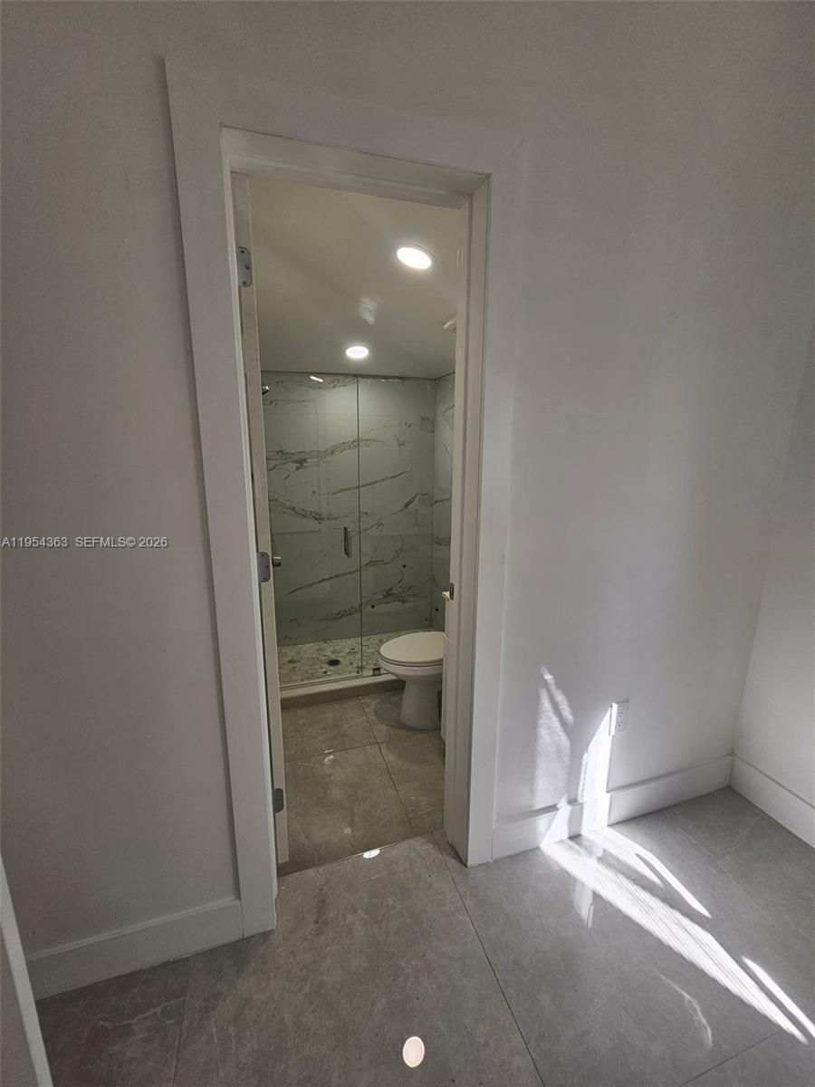 1148 Northwest 100th Street, Unit 1 Miami, FL 33150 - Photo 9 of 32 a bathroom with a glass shower door