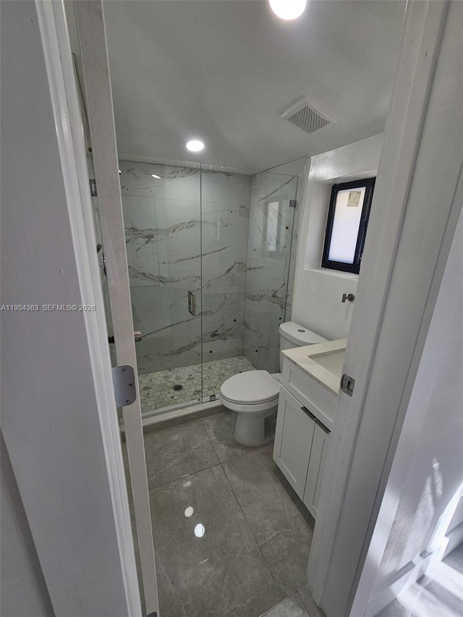 1148 Northwest 100th Street, Unit 1 Miami, FL 33150 - Photo 10 of 32 a bathroom with a shower toilet and sink