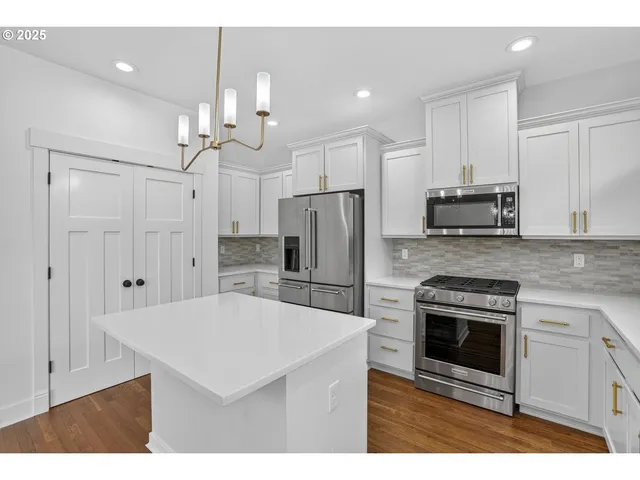 a kitchen with kitchen island a stove a refrigerator and a sink